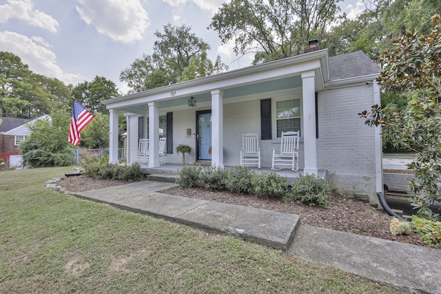 view of front facade featuring a front yard and covered porch