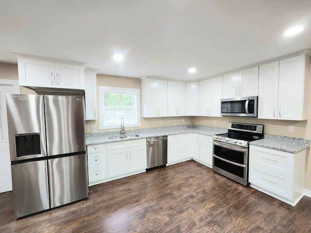 kitchen featuring light stone counters, dark wood-type flooring, sink, white cabinetry, and appliances with stainless steel finishes