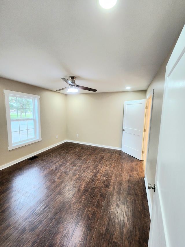 spare room with dark hardwood / wood-style floors and ceiling fan