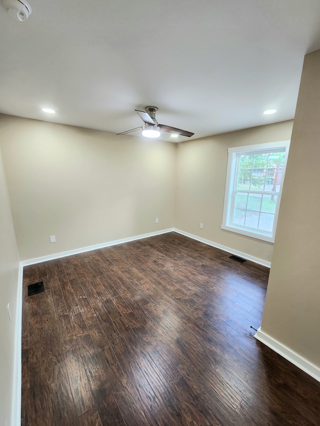 unfurnished room featuring dark wood-type flooring and ceiling fan