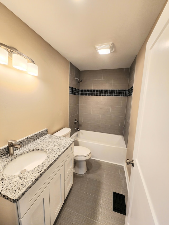 full bathroom with tiled shower / bath combo, vanity, and toilet