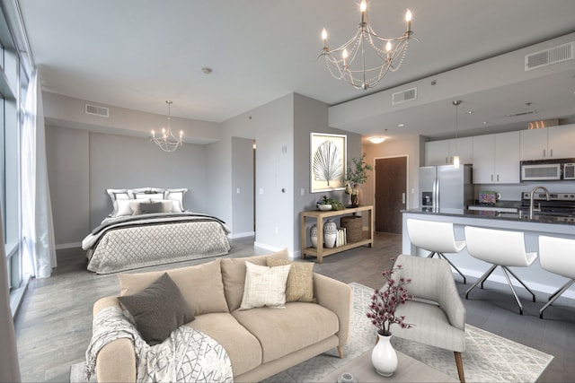 bedroom featuring a notable chandelier, dark wood-type flooring, sink, and stainless steel fridge