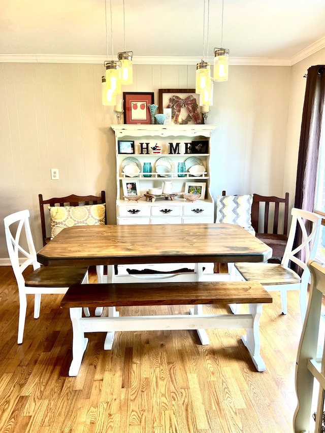 dining area with hardwood / wood-style flooring and crown molding