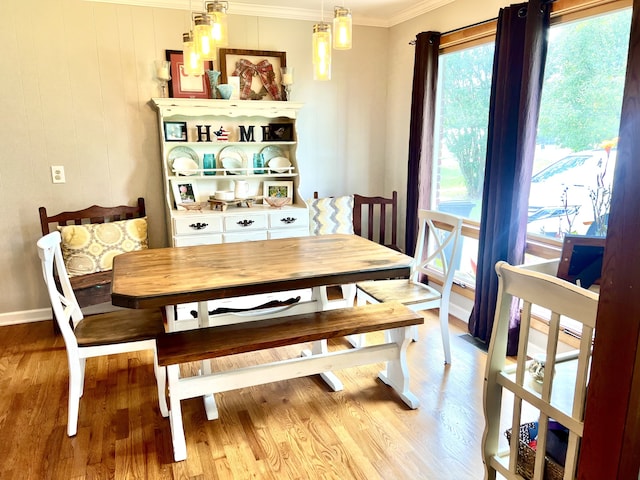 dining room with ornamental molding and light wood-type flooring