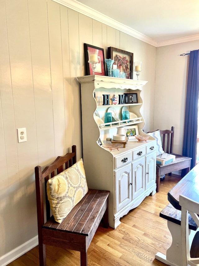 living area with light hardwood / wood-style floors and crown molding