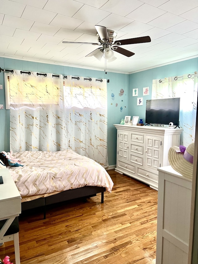 bedroom featuring multiple windows, ceiling fan, ornamental molding, and light hardwood / wood-style flooring