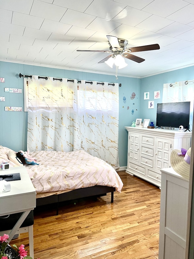 bedroom with crown molding, ceiling fan, and hardwood / wood-style floors