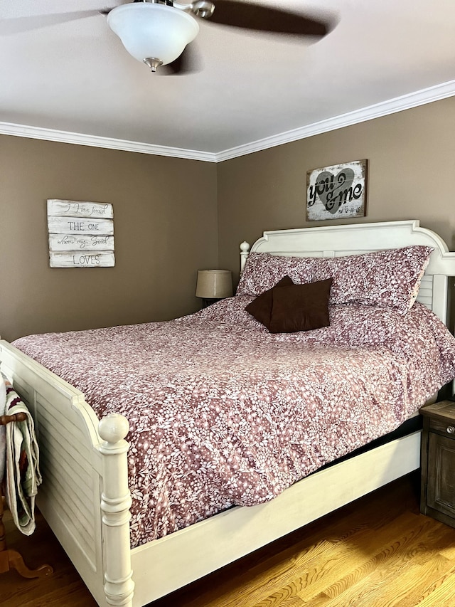 bedroom with crown molding, ceiling fan, and hardwood / wood-style floors