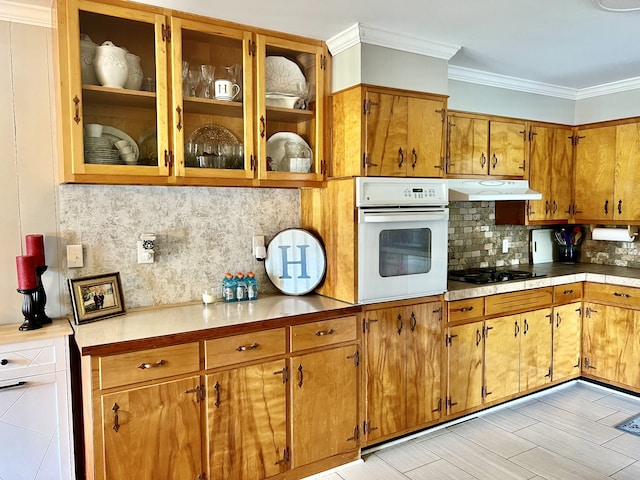 kitchen with crown molding, black gas stovetop, oven, and decorative backsplash