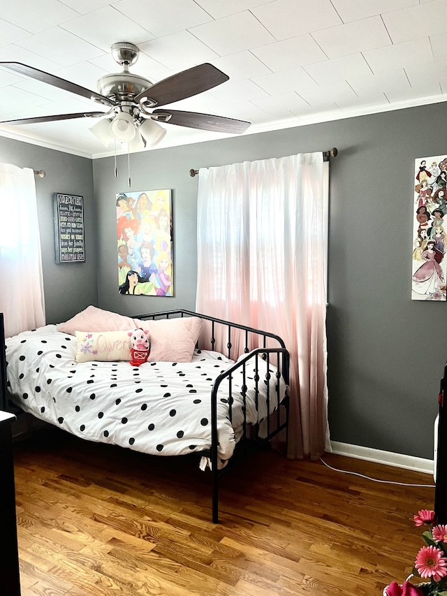 bedroom with hardwood / wood-style floors, ceiling fan, and crown molding