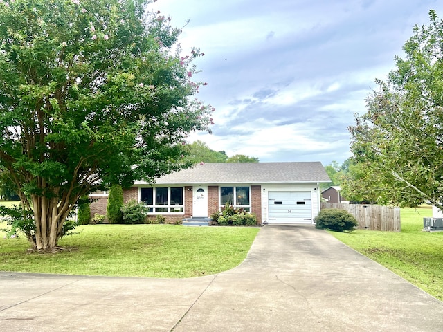 ranch-style home featuring a garage and a front lawn