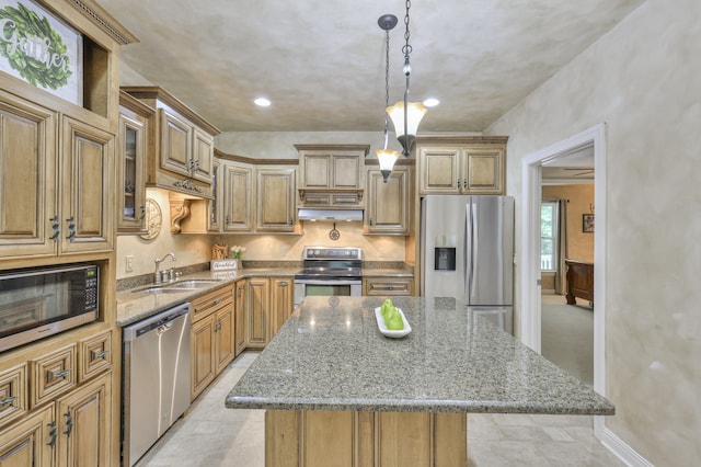 kitchen featuring pendant lighting, appliances with stainless steel finishes, a center island, sink, and light stone counters