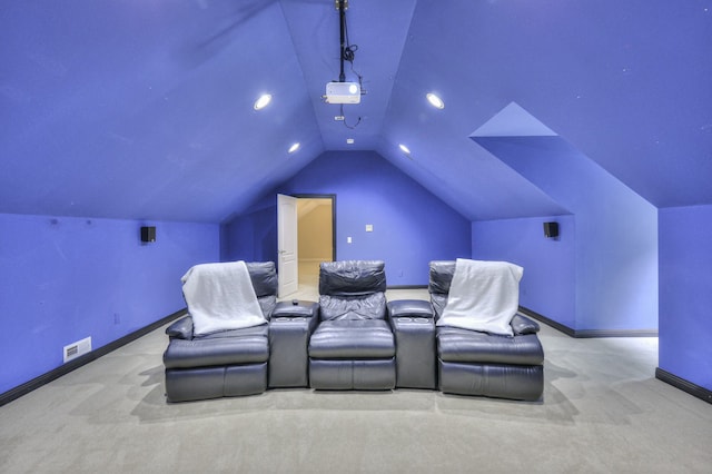 carpeted home theater featuring vaulted ceiling