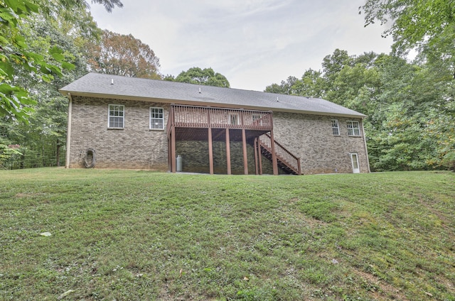 back of house featuring a lawn and a wooden deck