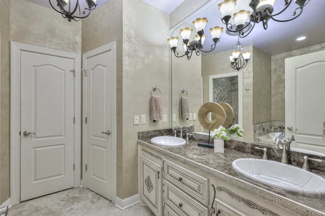 bathroom featuring vanity, a bathing tub, and a notable chandelier