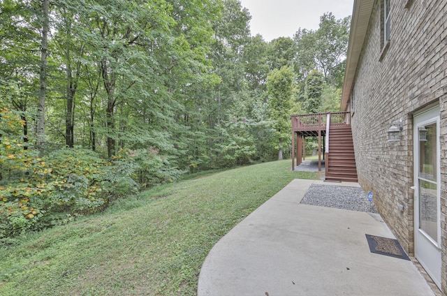 view of yard featuring a patio area and a wooden deck