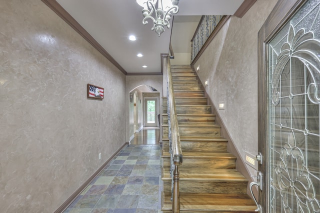 stairway featuring crown molding and a chandelier