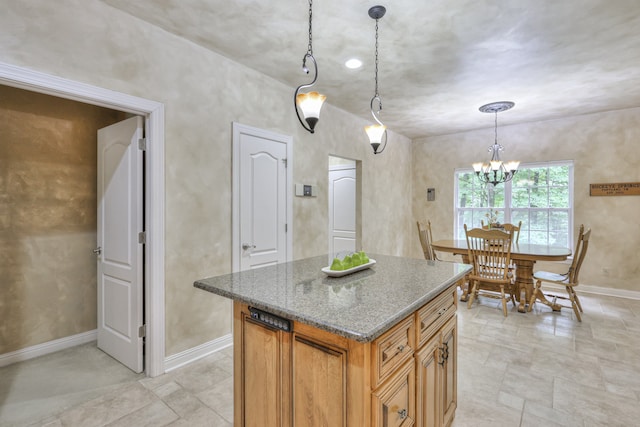 kitchen with a center island, pendant lighting, a notable chandelier, and stone counters