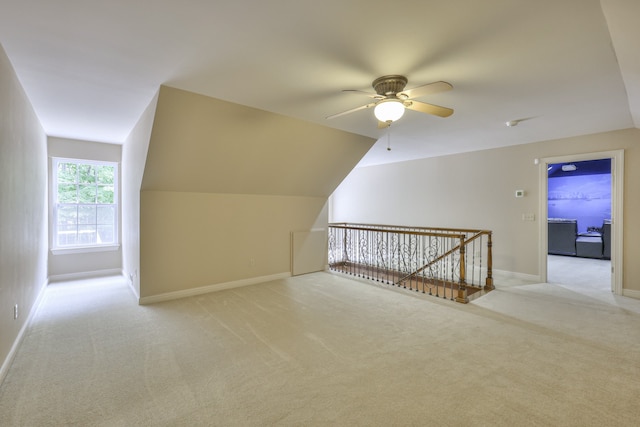 additional living space featuring light colored carpet, ceiling fan, and vaulted ceiling