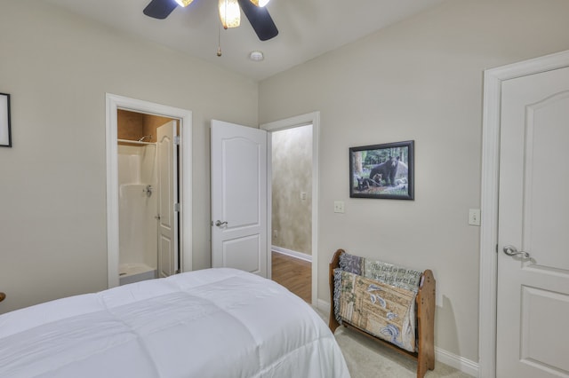 bedroom featuring light carpet, ensuite bathroom, and ceiling fan