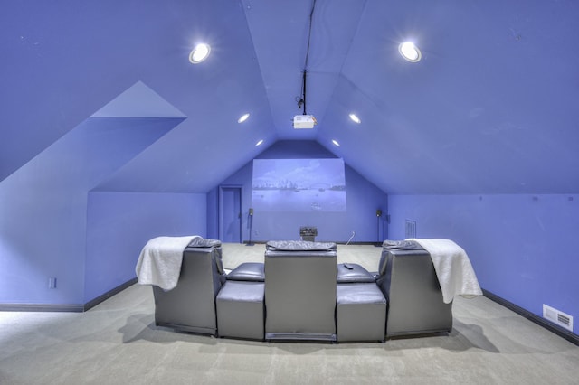 carpeted home theater featuring vaulted ceiling