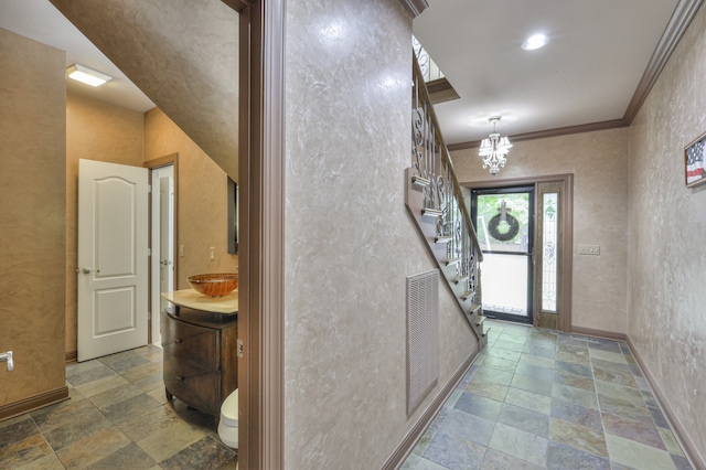 hallway featuring ornamental molding, an inviting chandelier, and sink