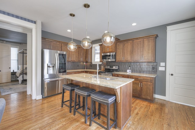 kitchen featuring a wealth of natural light, appliances with stainless steel finishes, and a kitchen island with sink