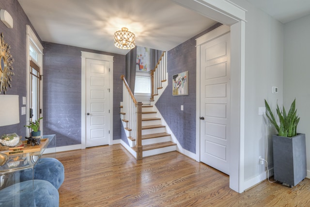 foyer entrance featuring hardwood / wood-style flooring and an inviting chandelier