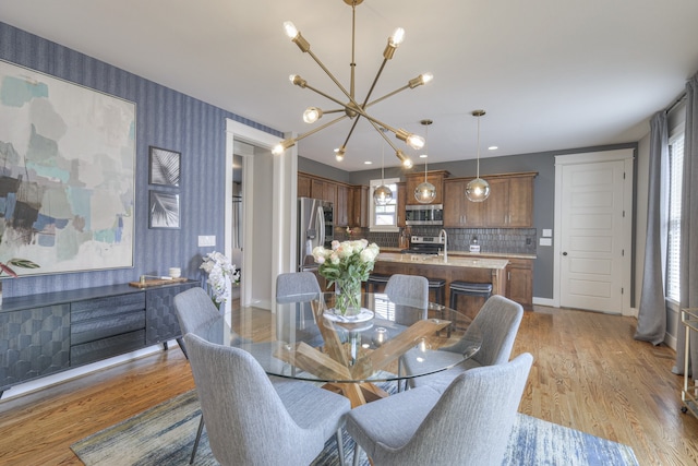 dining room with plenty of natural light, light hardwood / wood-style flooring, and a notable chandelier