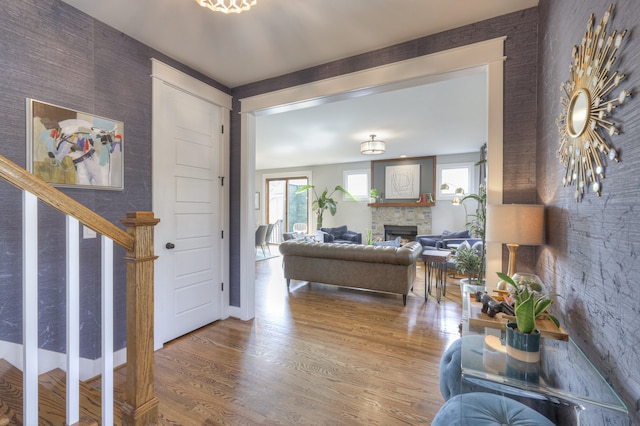 foyer entrance with hardwood / wood-style flooring and a stone fireplace