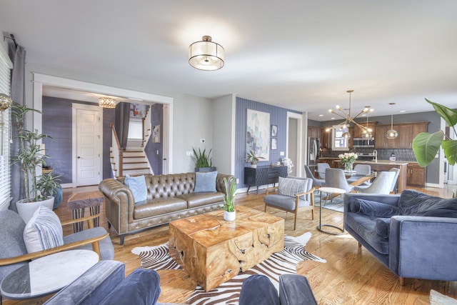 living room with light wood-type flooring and an inviting chandelier