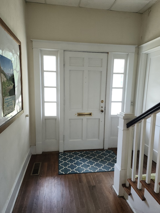 foyer entrance featuring dark hardwood / wood-style flooring and a drop ceiling