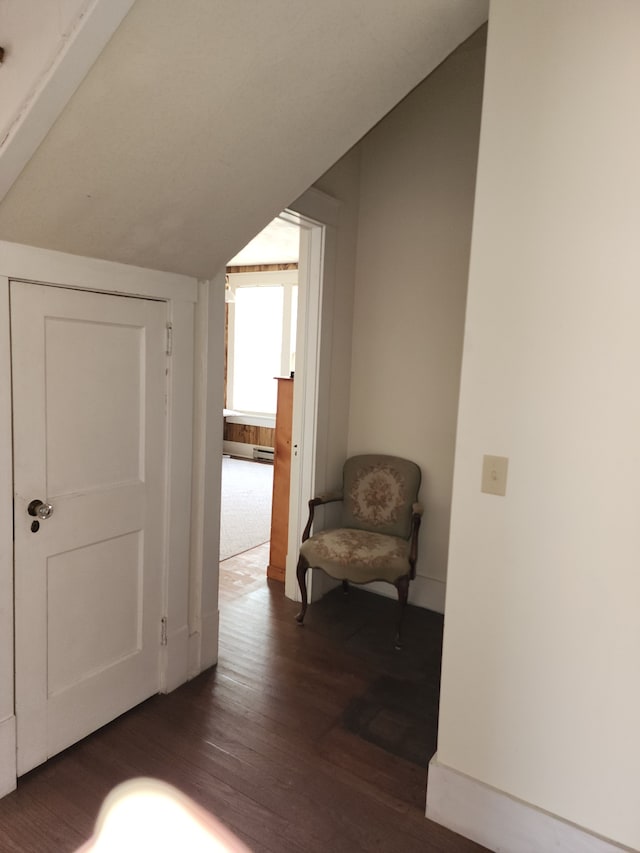 hall with vaulted ceiling and dark hardwood / wood-style flooring