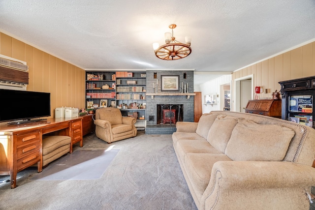 living room featuring a fireplace, an inviting chandelier, ornamental molding, carpet flooring, and a textured ceiling