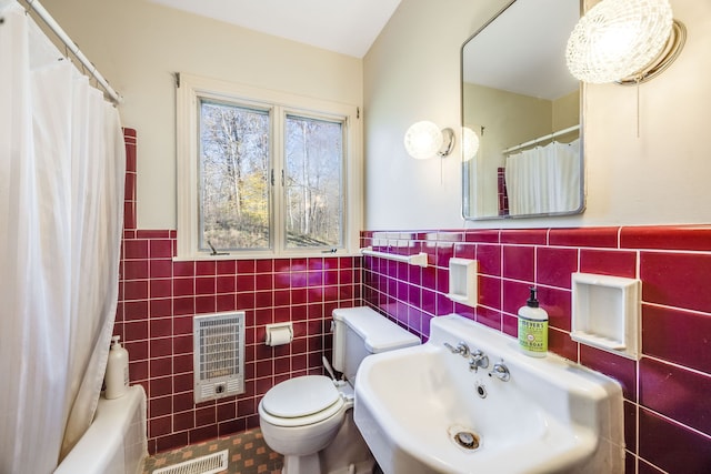 full bathroom with toilet, a sink, tile walls, wainscoting, and heating unit