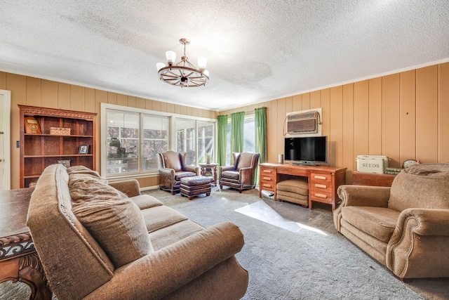 living area with carpet floors, a wall mounted air conditioner, a notable chandelier, and a textured ceiling