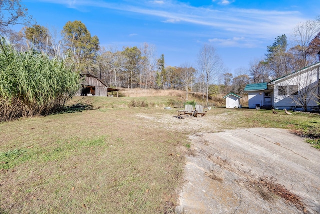 view of yard featuring driveway, an outdoor structure, and a barn