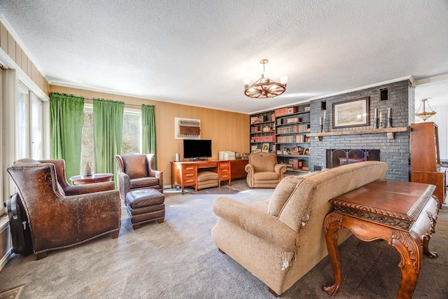 living room with ornamental molding, a textured ceiling, carpet floors, a fireplace, and a chandelier