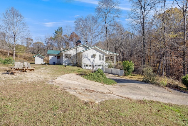 view of home's exterior with a chimney, concrete driveway, and a yard