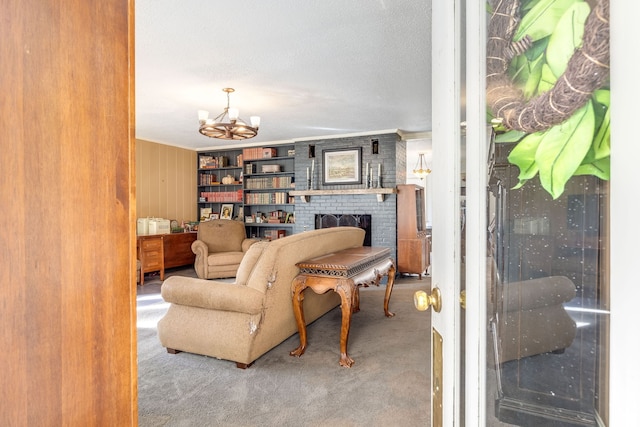 carpeted living room with crown molding, a brick fireplace, and a notable chandelier