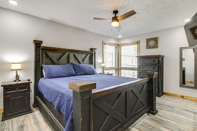 bedroom featuring light wood-type flooring, a textured ceiling, and ceiling fan