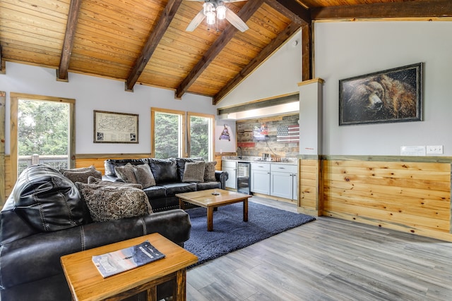 living room featuring wine cooler, beamed ceiling, wooden ceiling, hardwood / wood-style flooring, and ceiling fan