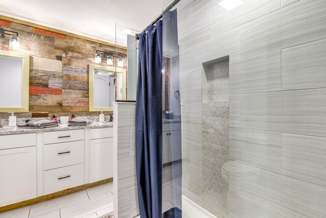 bathroom featuring vanity, a shower with curtain, and wooden walls