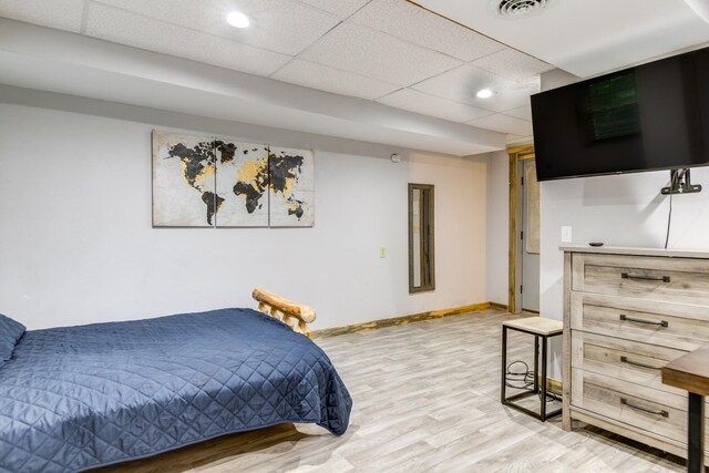 bedroom with hardwood / wood-style floors and a paneled ceiling