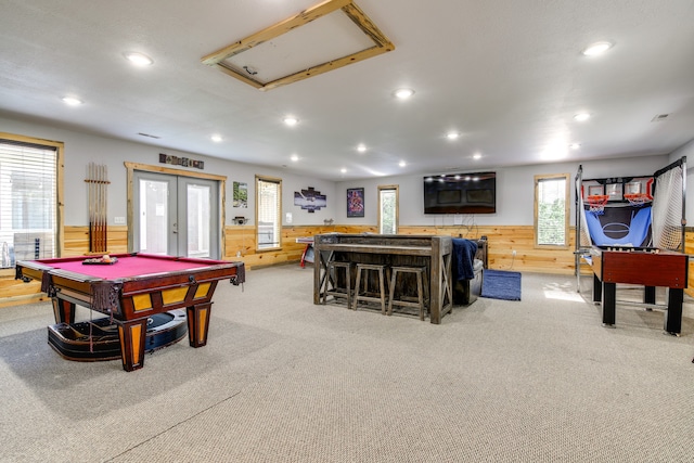 recreation room featuring french doors, plenty of natural light, pool table, and wooden walls