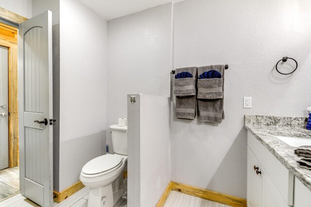 bathroom featuring vanity, toilet, and hardwood / wood-style flooring