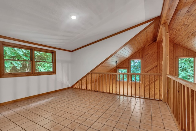 additional living space featuring wood walls, tile patterned flooring, and vaulted ceiling