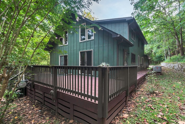 back of property with a wooden deck and central AC