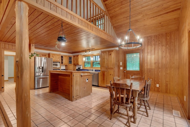 kitchen with light tile patterned floors, a center island, wooden ceiling, stainless steel appliances, and a chandelier