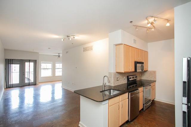 kitchen with kitchen peninsula, sink, appliances with stainless steel finishes, and light brown cabinetry